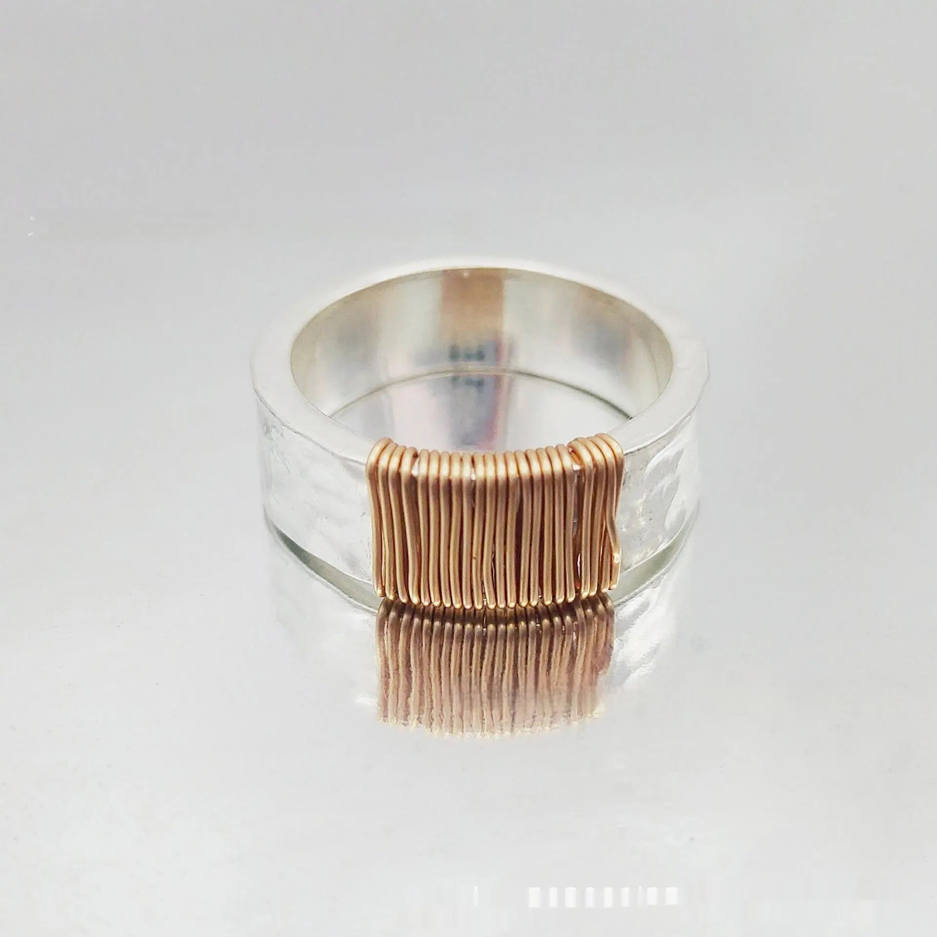 Copper bracelet ring with geometric coil design in silver gold colour on wrist