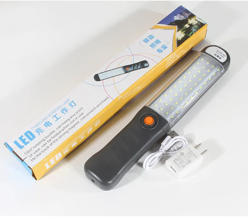 Grey multifunctional LED work light with magnetic base and 360° rotation on a metal surface