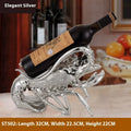 Lobster-shaped natural resin wine rack ornament in rose gold or silver colour on a table.
