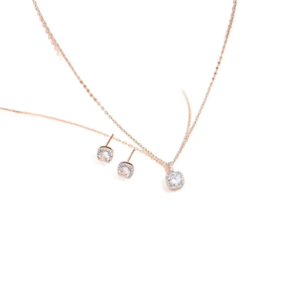 Women's minimalist square cubic zirconia necklace and earring set in gold finish on a light background