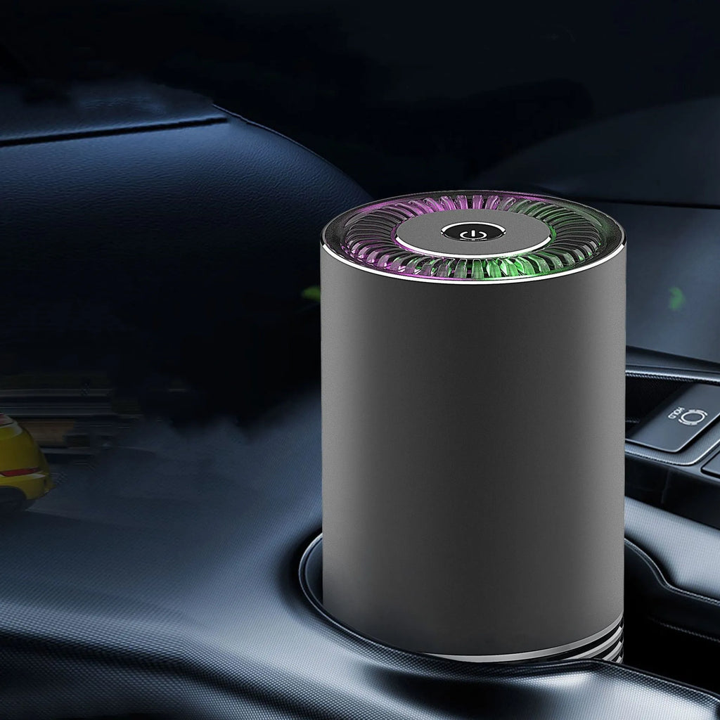 Compact black metallic car air purifier with USB cable on a car dashboard.