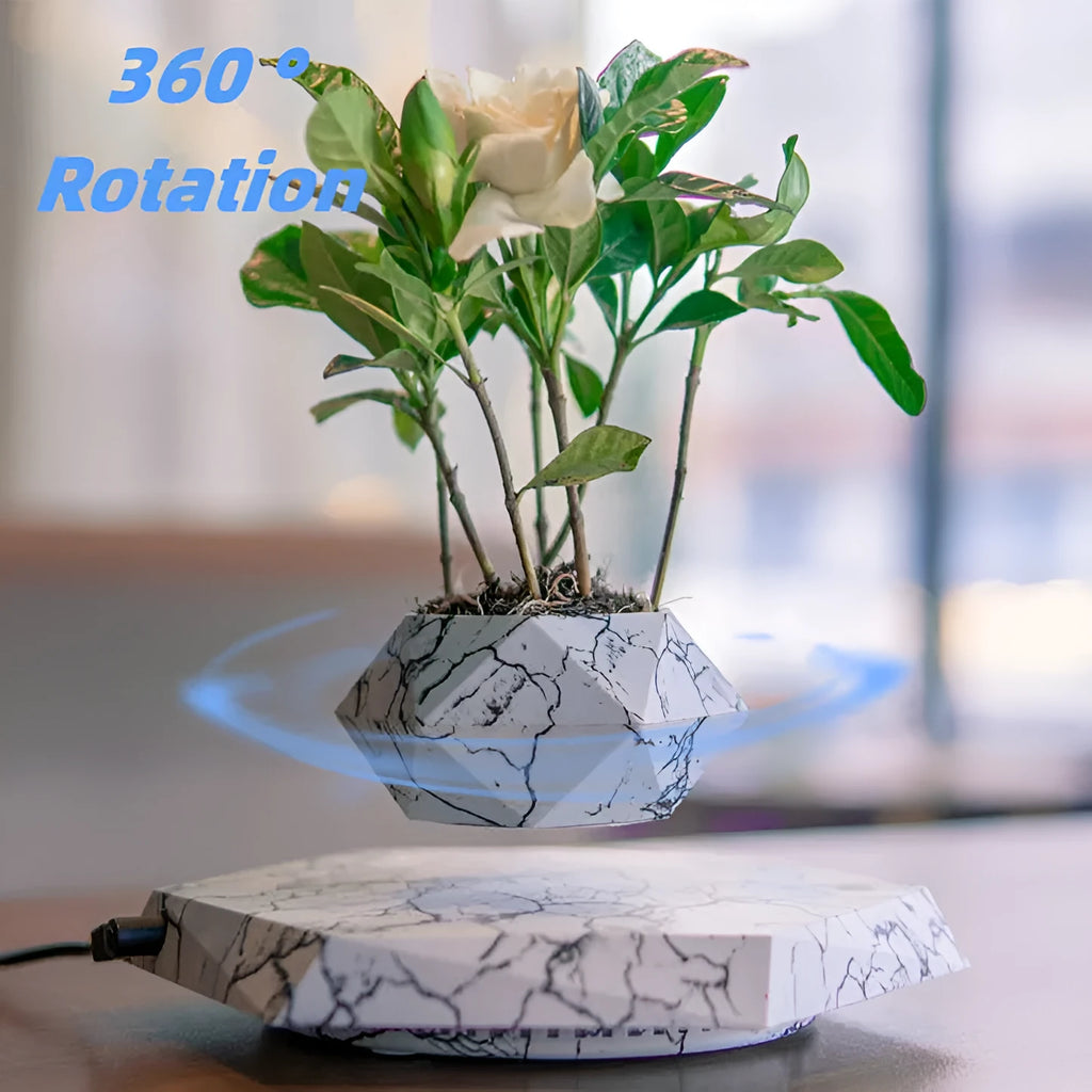 Small marble-colour magnetic levitation plant pot floating and rotating above its floor-standing base.