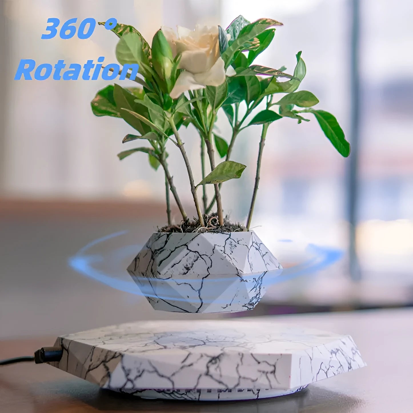 Small marble-colour magnetic levitation plant pot floating and rotating above its floor-standing base.