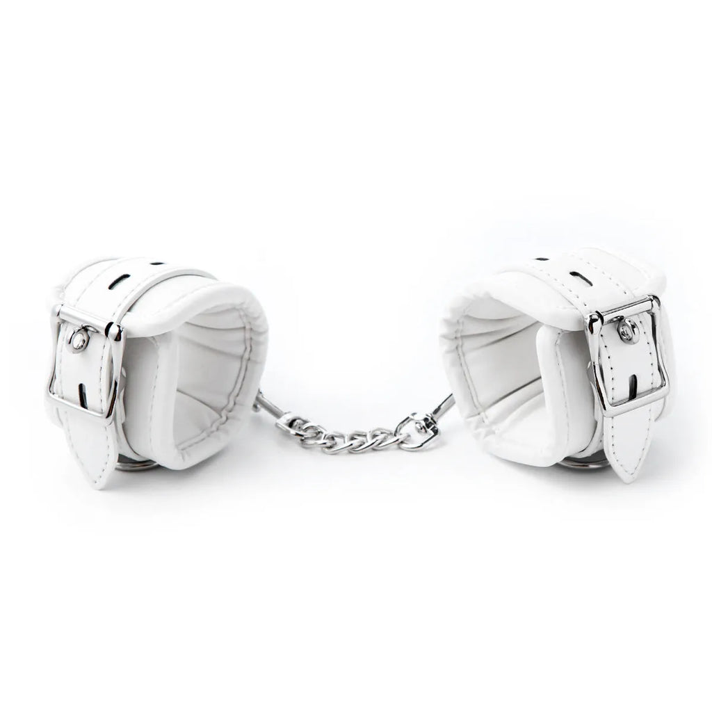 White PU sponge bondage restraint set showing handcuffs, foot cuffs, and a neck cuff.