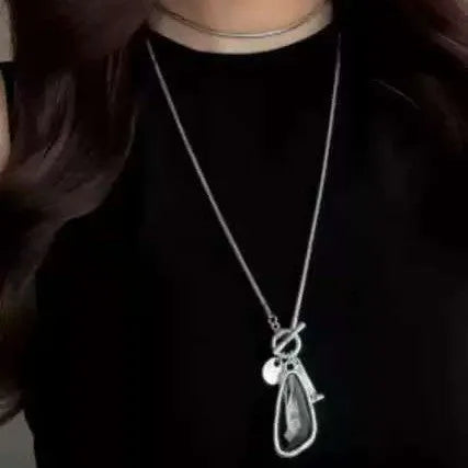 Long geometric plaid pendant necklace on a snake bones chain in alloy metal.