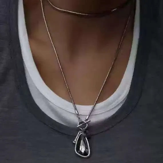 Long geometric plaid pendant necklace on a snake bones chain in alloy metal.