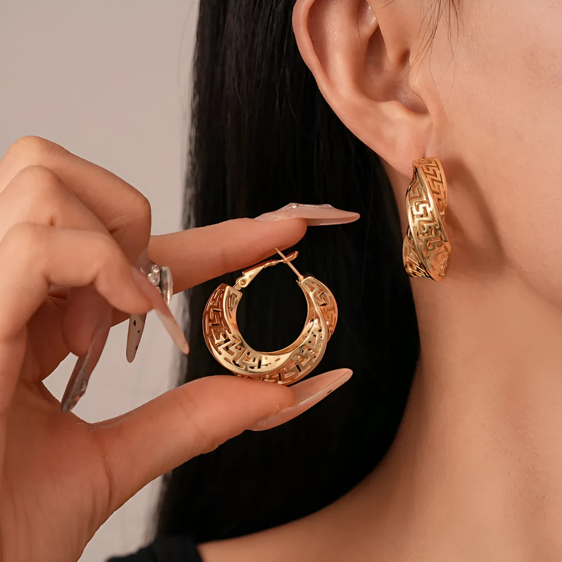 Women's geometric hollow stud earrings with twisted round design in silver or gold electroplated finish