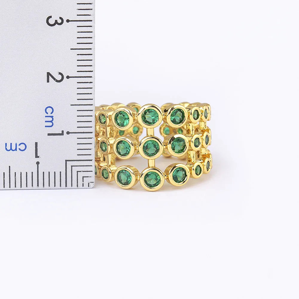 Copper ring with 18K gold colour plating and large green zircon stones on a wide band.