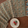 Dark blue Nordic jacquard stripe table runner with bouquet pattern and tassel fringe on a wooden table
