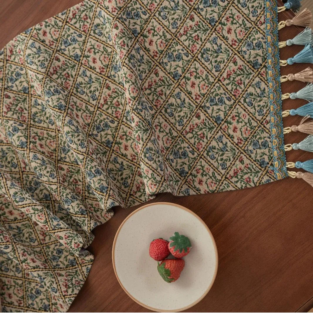 Dark blue Nordic jacquard stripe table runner with bouquet pattern and tassel fringe on a wooden table