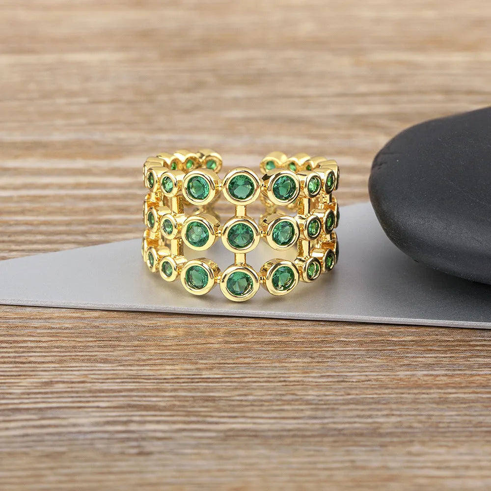 Copper ring with 18K gold colour plating and large green zircon stones on a wide band.