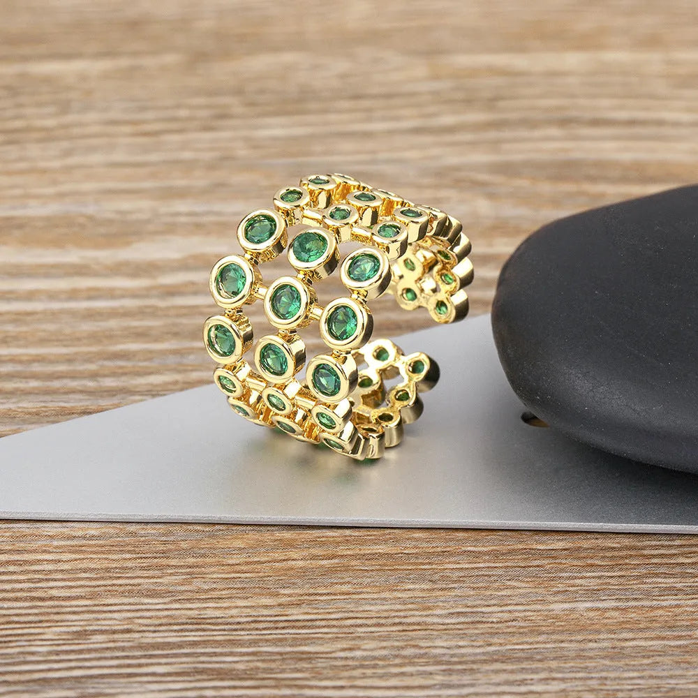 Copper ring with 18K gold colour plating and large green zircon stones on a wide band.