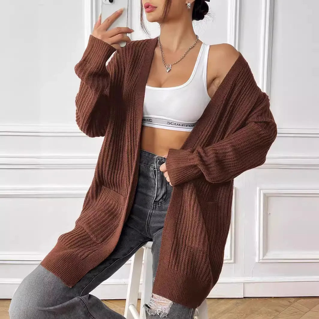 Women's dark green loose-fit cardigan sweater with two front pockets and long sleeves.
