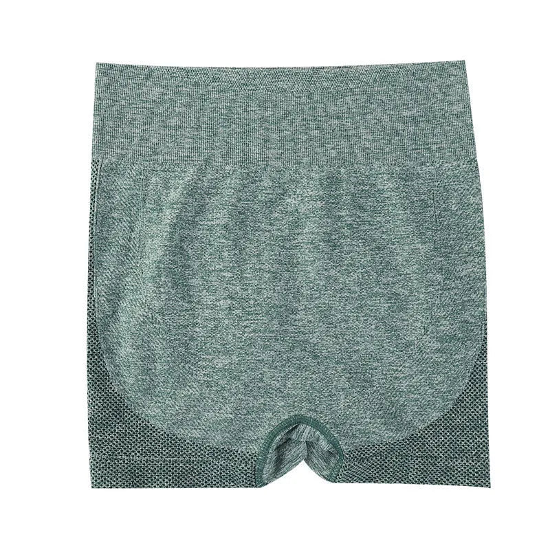 Woman wearing high-waisted black quick-dry yoga fitness shorts with a seamless waistband.