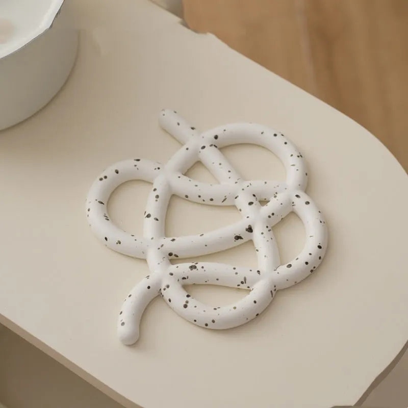 Ceramic heat proof mat with irregular organic shape in solid colour for dining table protection