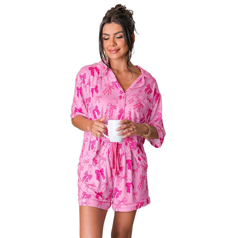 Women's pink bow print two-piece polyester pajama set showing top and pants