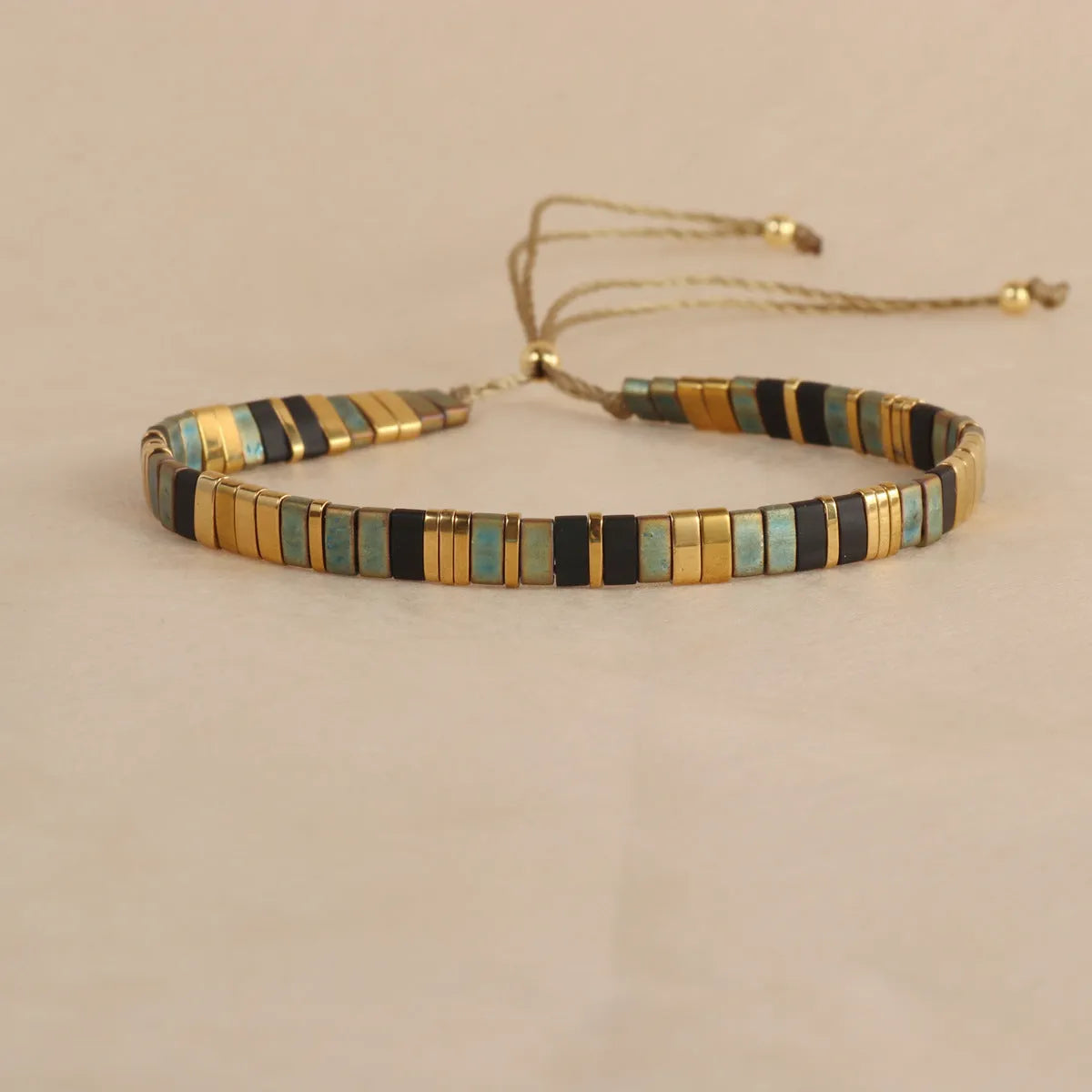 Geometric glass bead pull bracelet in retro green, black, light blue, red, and milky white colours.
