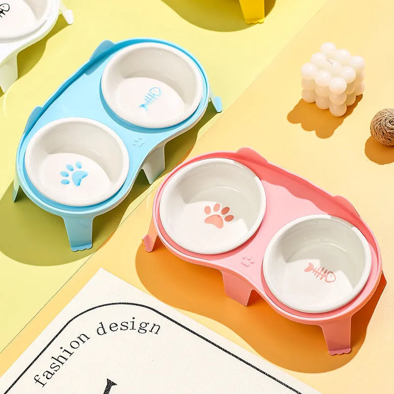 Blue ceramic cat bowl set on white elevated stand with hook, showing tilted food and water dishes.