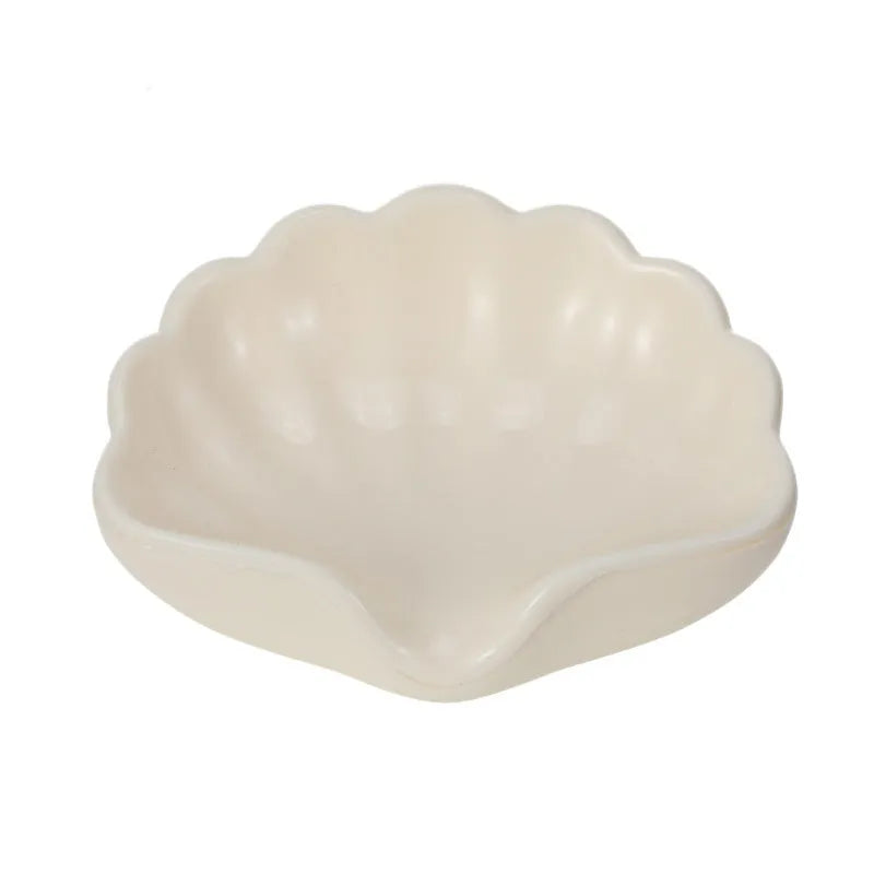 White and pink shell-shaped plastic soap dishes for bathroom countertops.