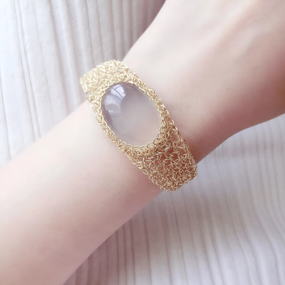 14k gold wire natural white chalcedony bracelet with adjustment chain on neutral background