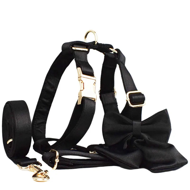 A complete cloth dog accessory set showing a collar, leash, chest strap, vest, and decorative bow in matching colours.