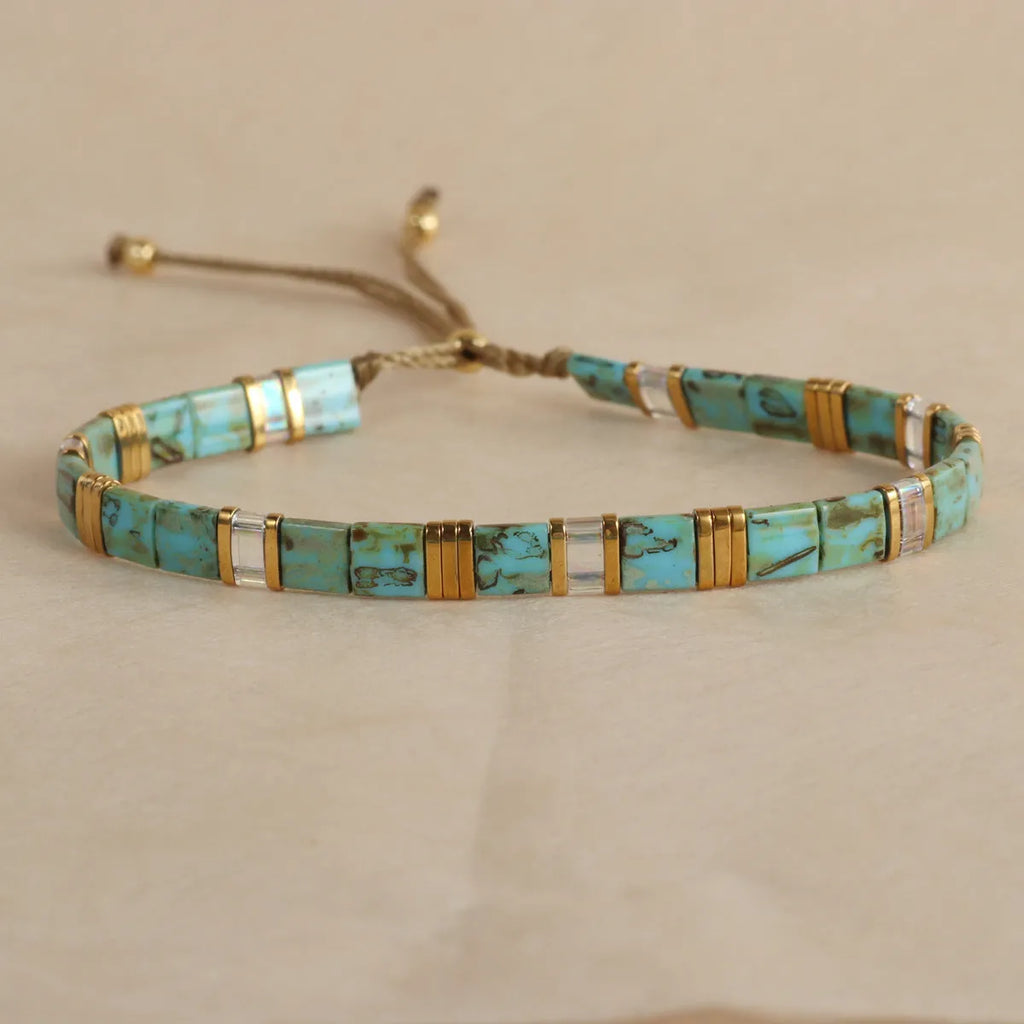 Geometric glass bead pull bracelet in retro green, black, light blue, red, and milky white colours.