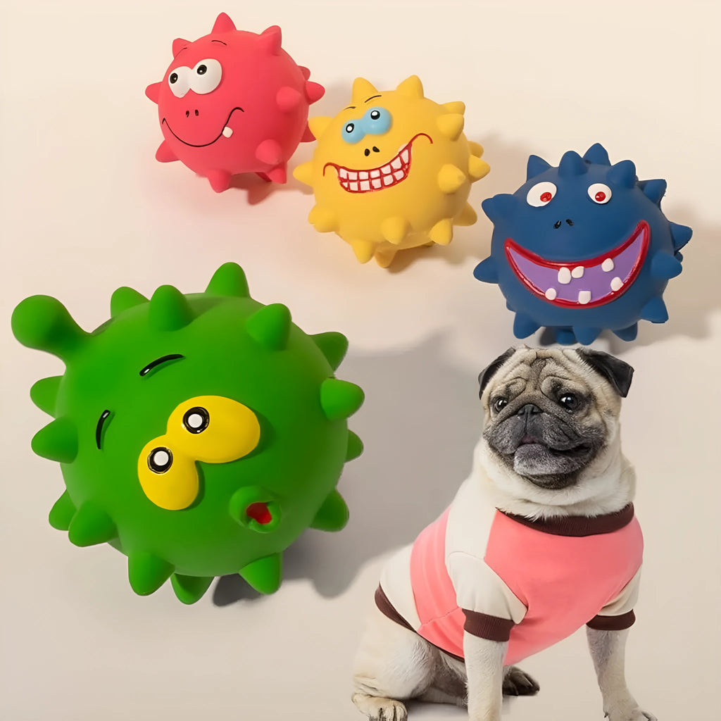 Four colourful squeaky dog balls with cute faces on textured natural latex rubber surfaces