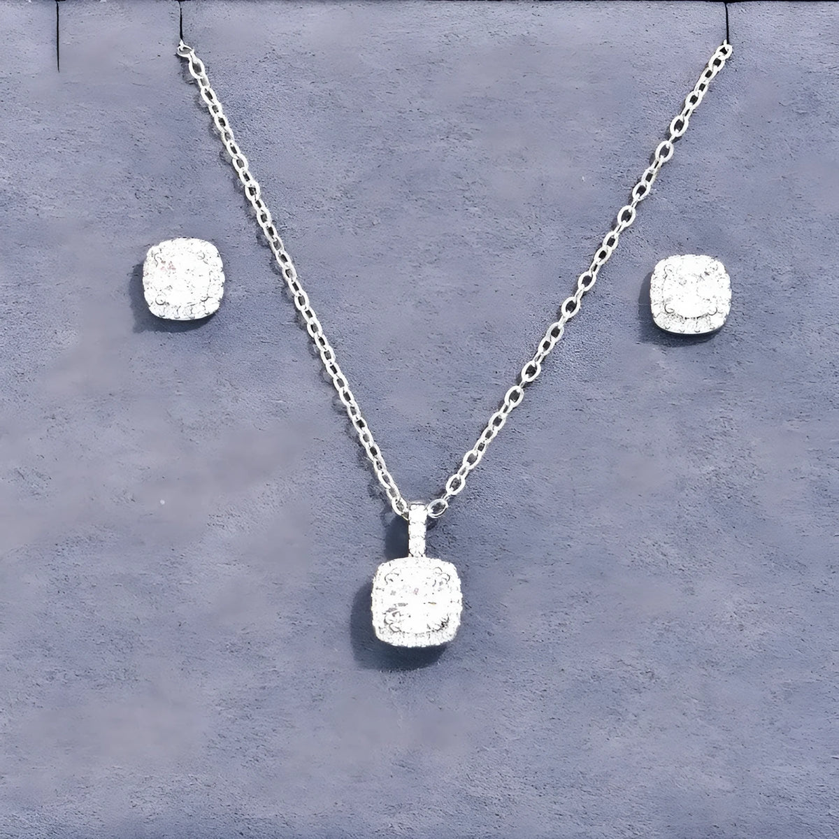 Women's minimalist square cubic zirconia necklace and earring set in gold finish on a light background
