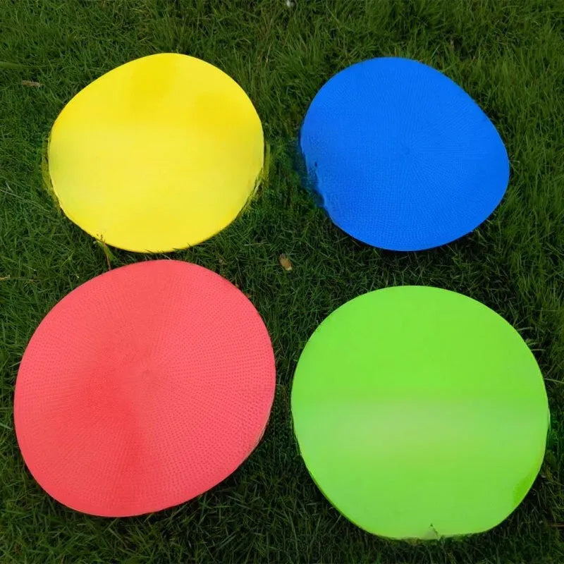 Soft yellow football training target pad, 23cm diameter flat disc on grass.
