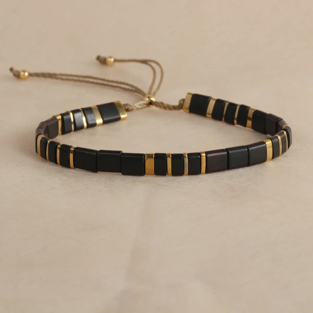 Geometric glass bead pull bracelet in retro green, black, light blue, red, and milky white colours.