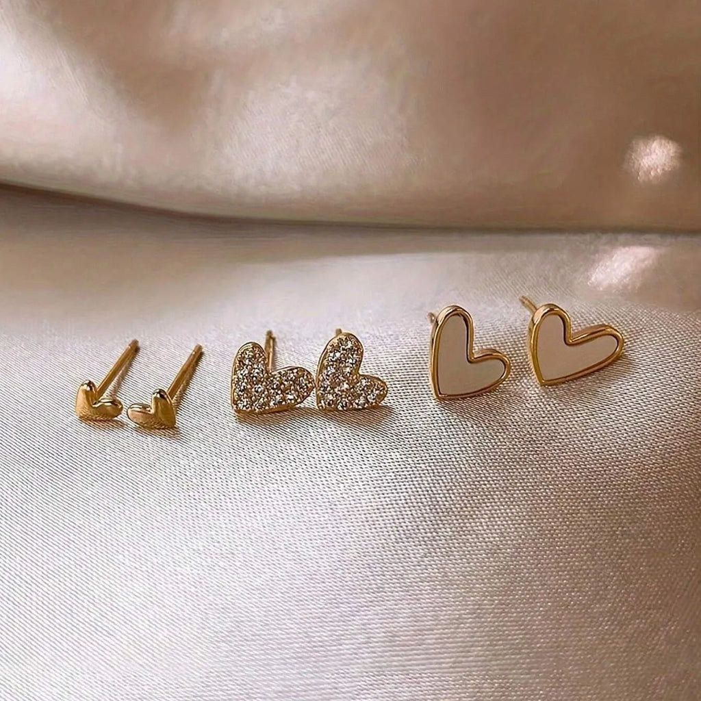 Three pairs of heart-shaped alloy earrings with electroplated finish in gold, black, black-white, and pink colours