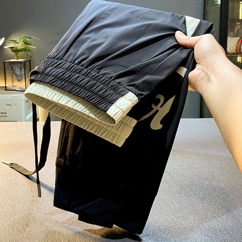 Black men's ultra-thin cotton ankle banded cropped trousers laid flat showing casual design