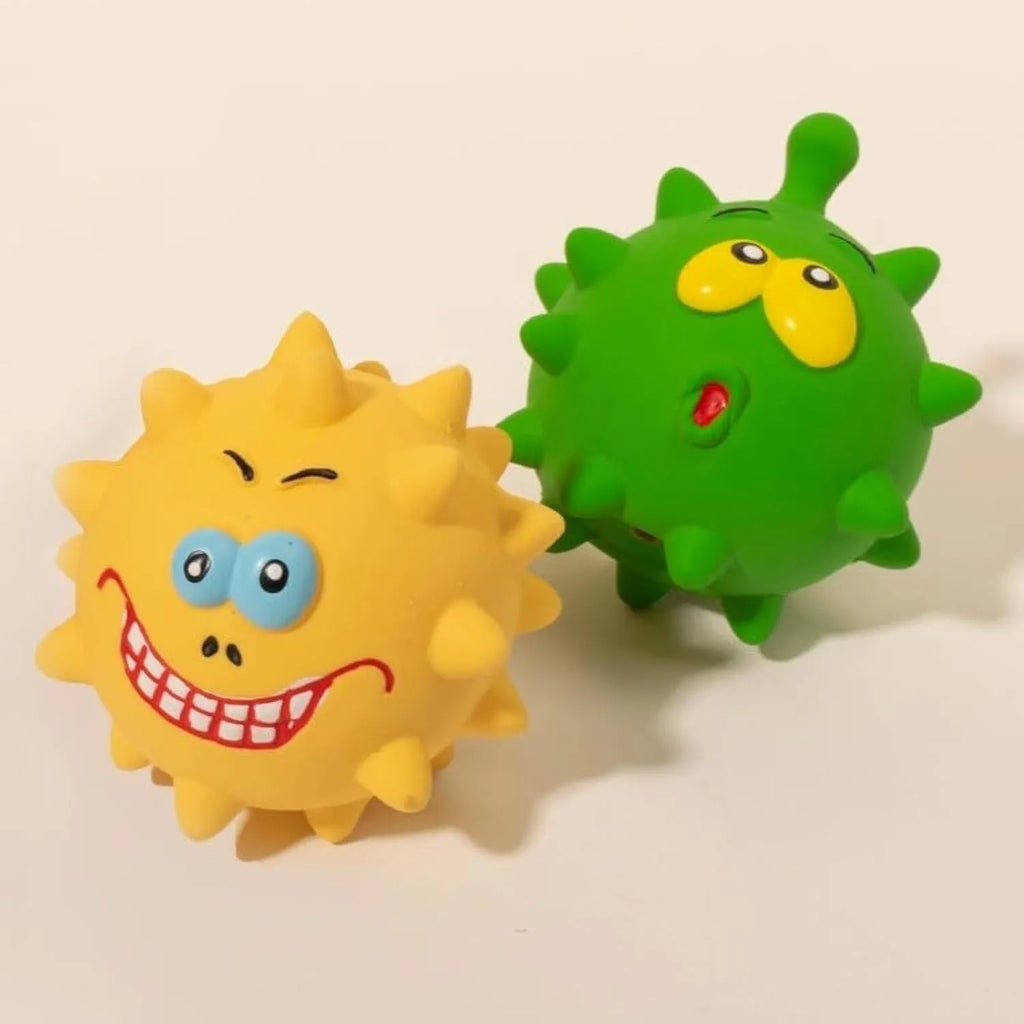 Four colourful squeaky dog balls with cute faces on textured natural latex rubber surfaces