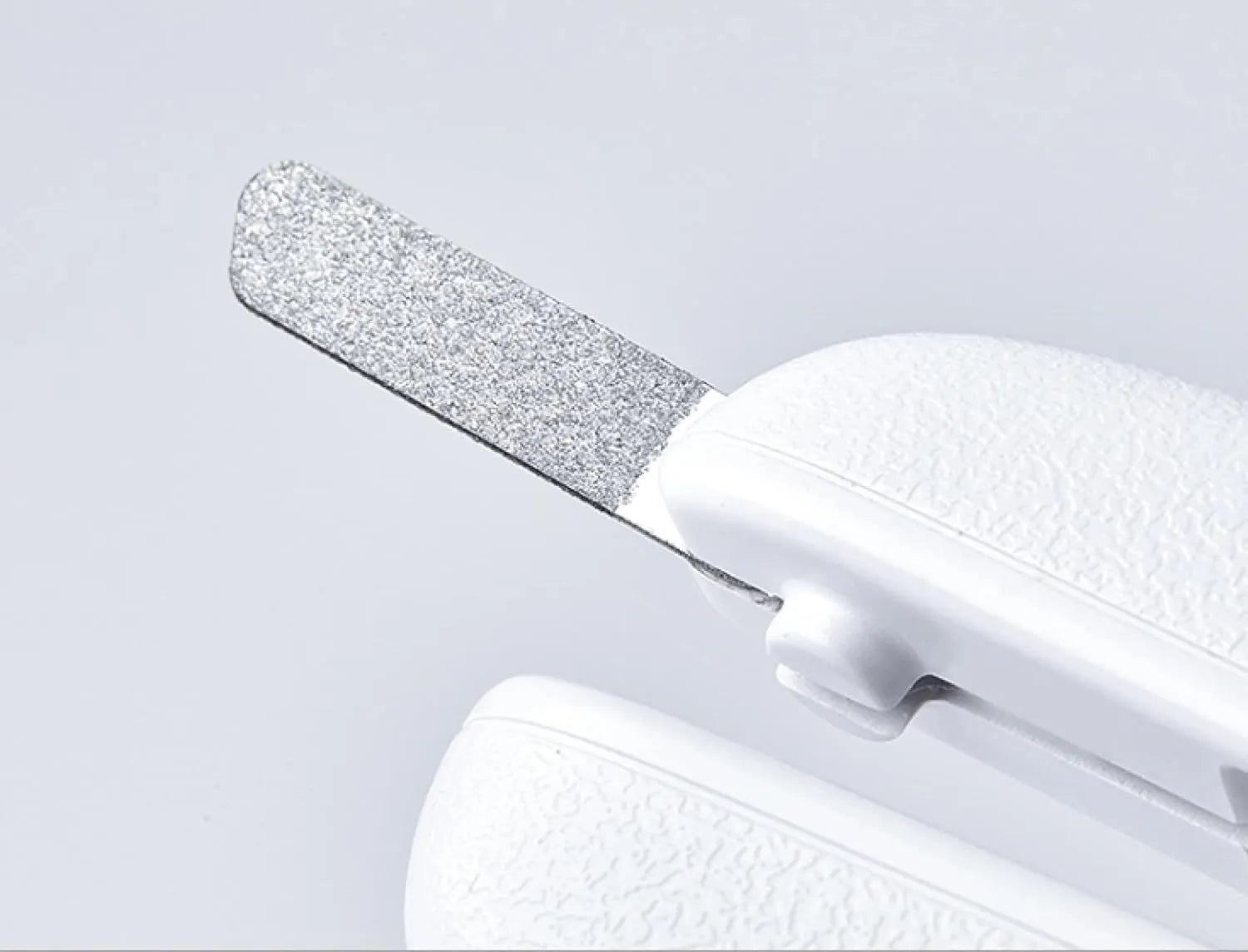 White pet nail clippers with LED light, transparent anti-splash guard open, and separate nail file.