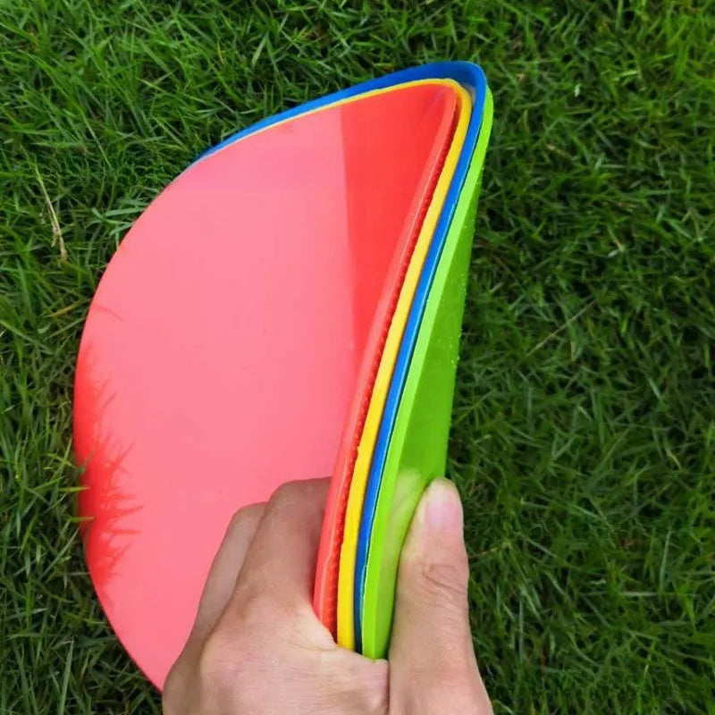 Soft yellow football training target pad, 23cm diameter flat disc on grass.