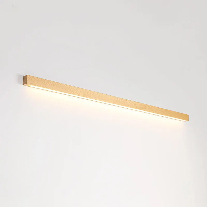 A long, slim walnut-coloured wooden and acrylic LED strip light mounted on a wall.