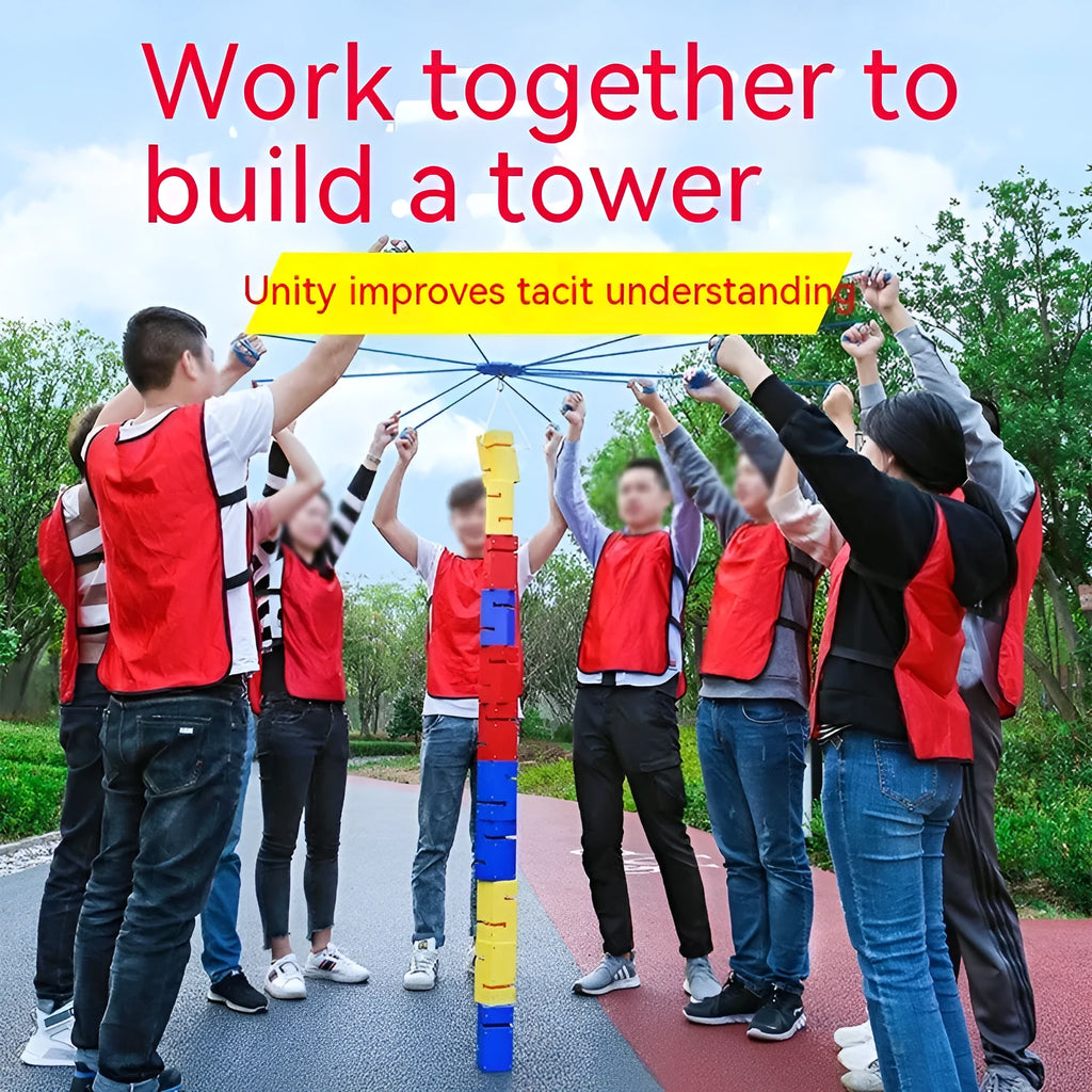 Outdoor team building equipment set with coloured plastic blocks, pull ropes, and a metal hook frame on grass.