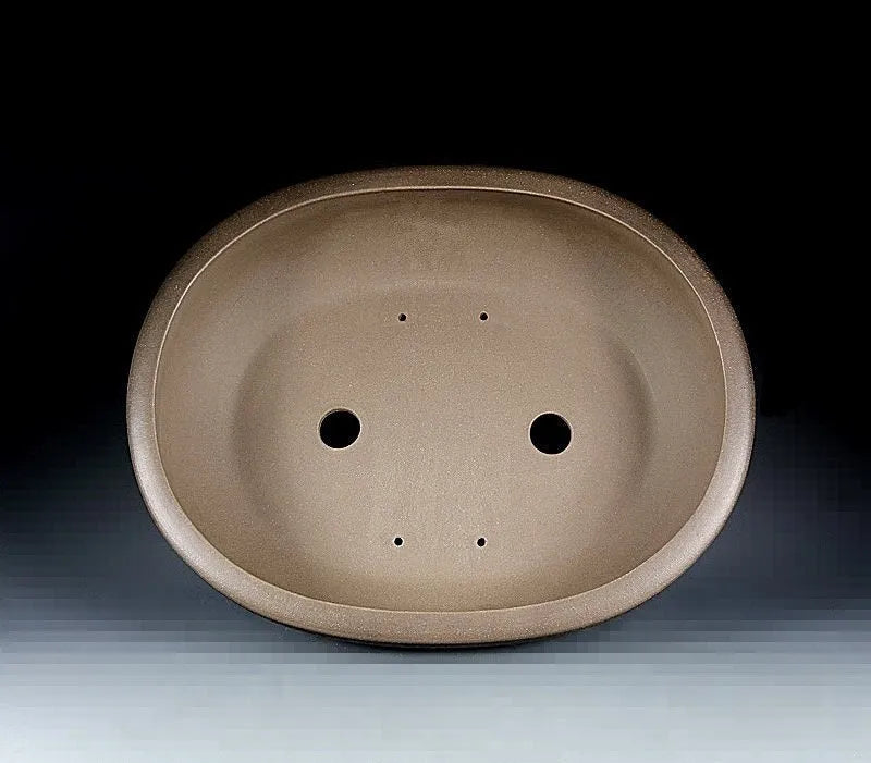 Handmade large oval purple sand flowerpot for plants on a desktop.