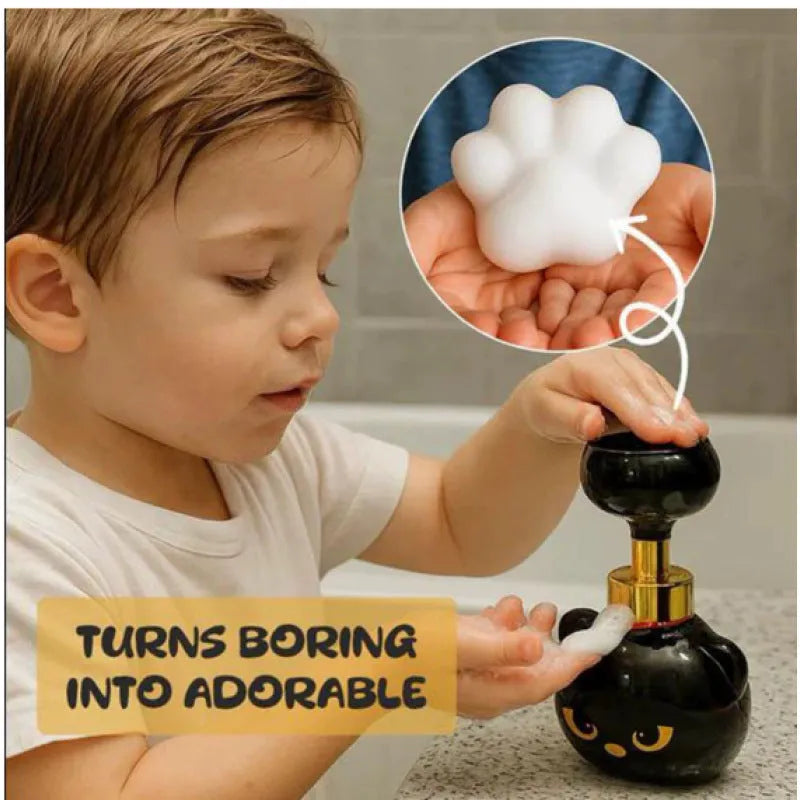Black cartoon cat shaped manual foam soap dispenser on a counter.