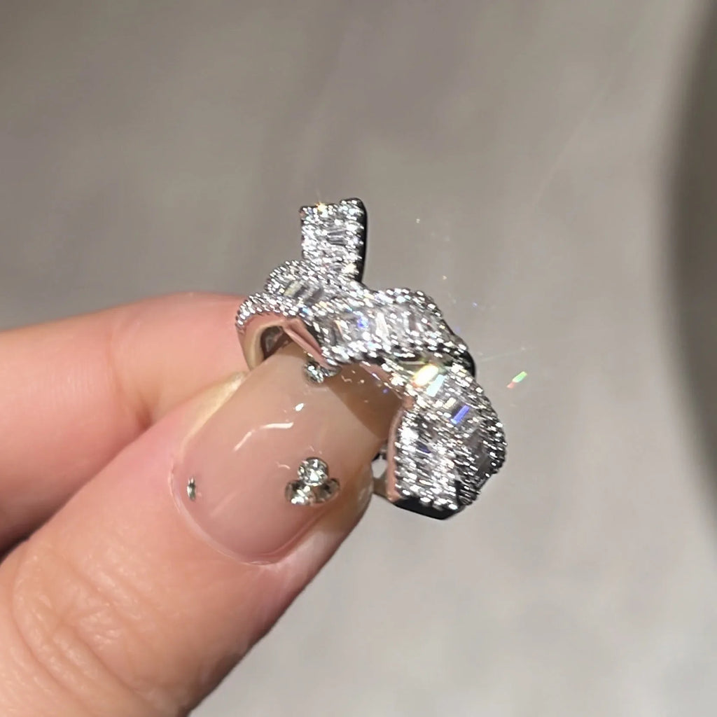 Silver cross open ring with bow shape in copper with electroplated finish on neutral background