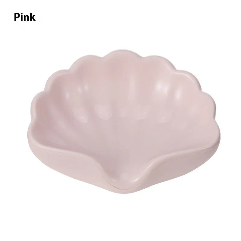 White and pink shell-shaped plastic soap dishes for bathroom countertops.