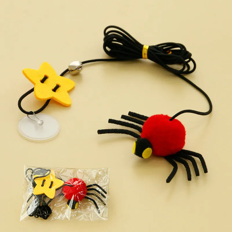 Red cat toy hanging from door with elastic rope, feather stick, bell, and spider decoration