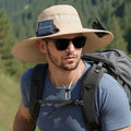Man wearing a beige wide-brim solar fan hat outdoors, showing the built-in fan and solar panels.