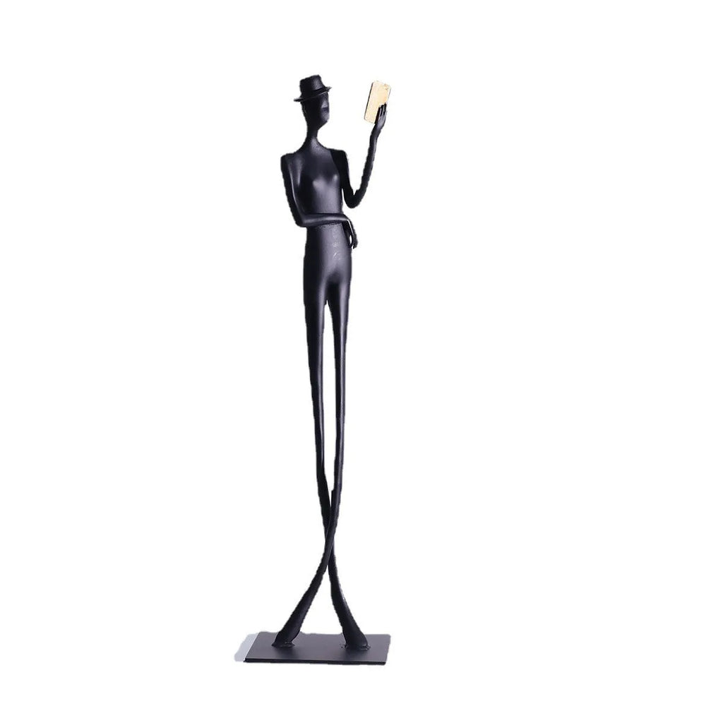 Black cast aluminium sculpture of a woman reading, measuring 51cm tall on a desktop.