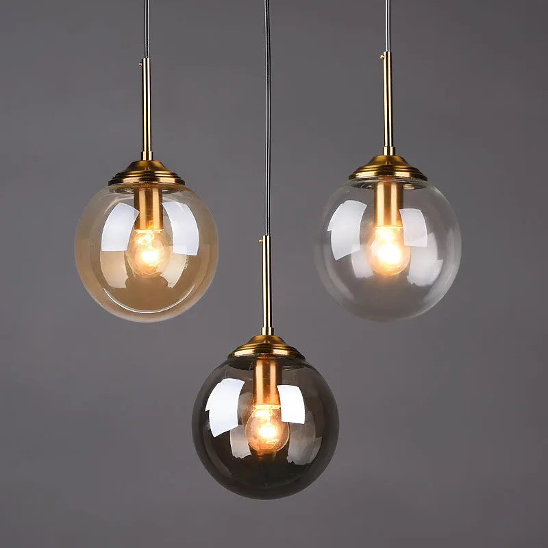 Modern Nordic style ceiling chandelier with spherical glass shades in clear, amber and grey.