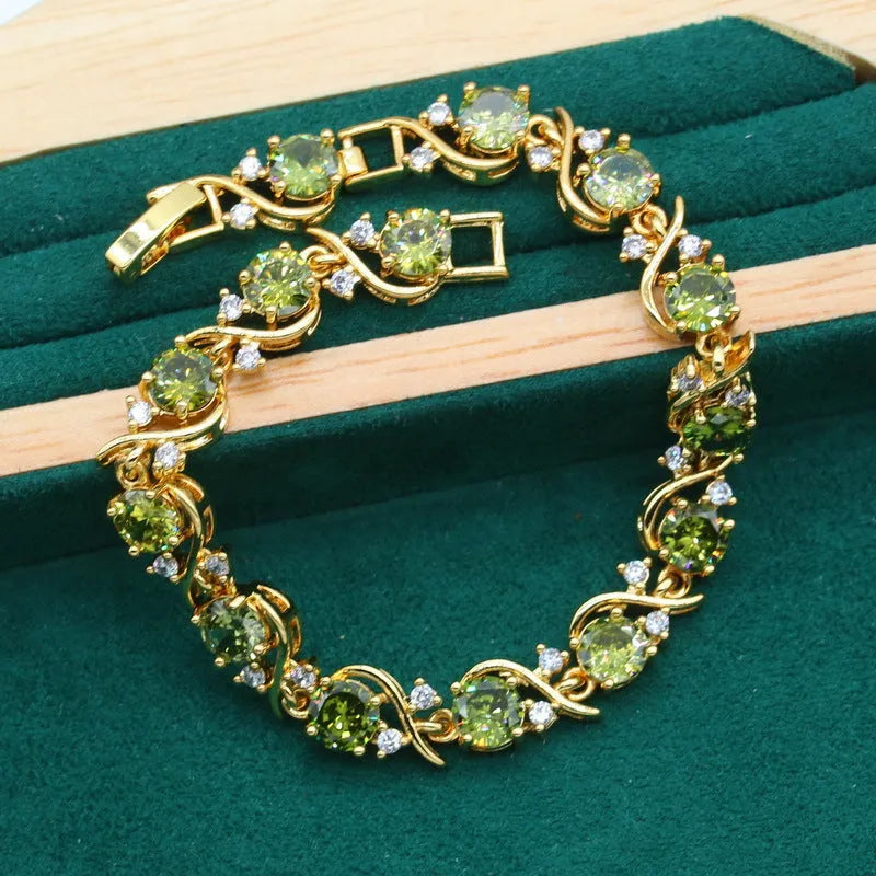 Olive green rhinestone jewellery set with necklace, earrings and ring featuring cross, crown and numeral designs.