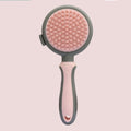Double-sided pink cat brush with release button and matching flea comb for pet grooming