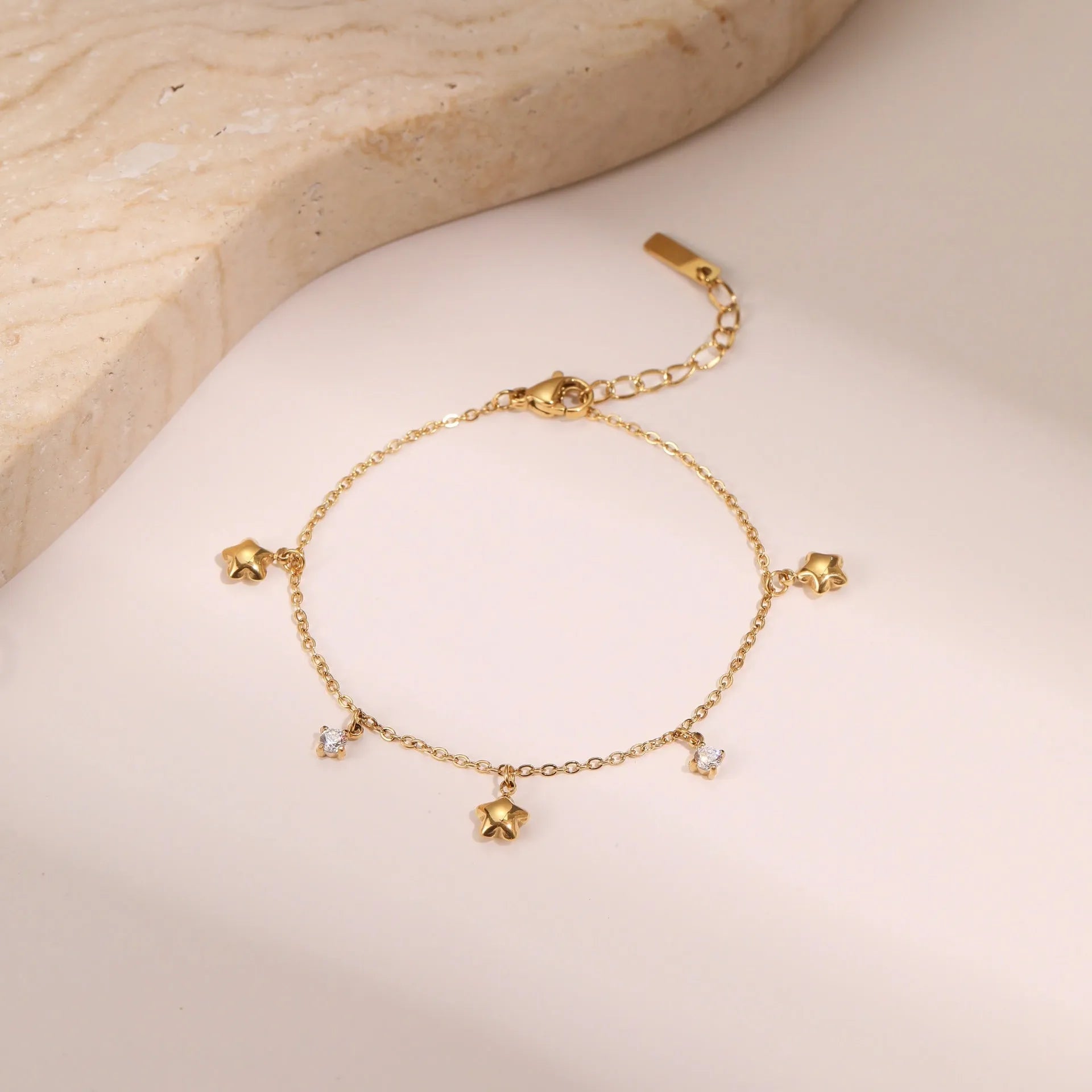 Women's stainless steel bracelet with a geometric star pendant, shown in gold and steel colour finishes.