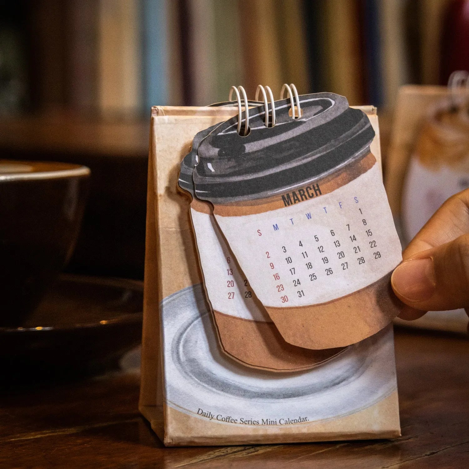 Set of four different 2025 mini paper desk calendars with simple modern designs on a desk.
