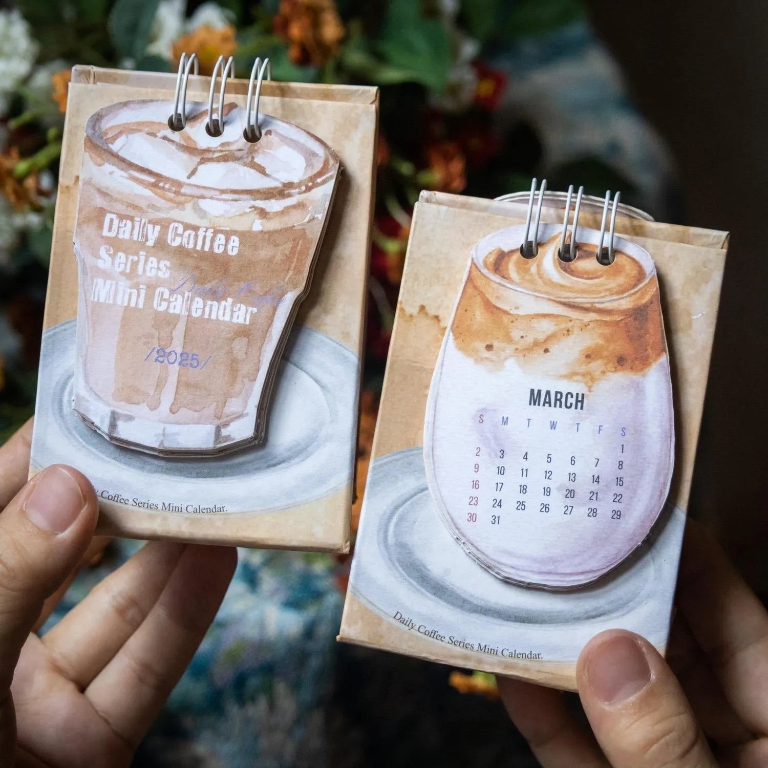 Set of four different 2025 mini paper desk calendars with simple modern designs on a desk.